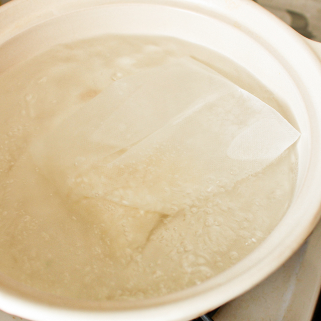 鍋で沸騰したお湯の中に、お米の入った炊飯袋を入れる
